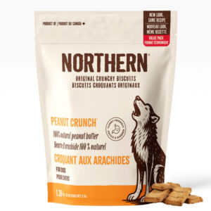 A 1.36 kg bag of Northern Peanut Crunch dog biscuits features a beige package with orange accents, bilingual text, a howling wolf illustration, and images of the biscuits next to the bag.