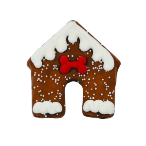 Gingerbread doghouse cookie decorated with white icing resembling snow and a red bone-shaped decoration above the door.