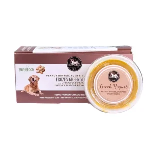 A container of peanut butter and pumpkin frozen Greek yogurt for dogs, labeled as human-grade, sits in front of its brown and white packaging featuring a happy dog and images of peanuts.