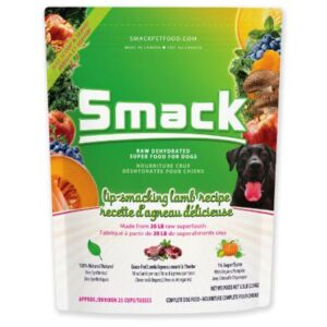 A bag of Smack brand raw dehydrated superfood for dogs, featuring a lamb recipe. The package is green and shows images of fresh fruits, vegetables, and a black dog. Various product benefits and details are printed on the bag.