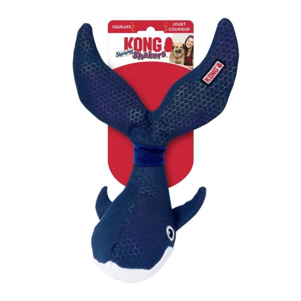 A plush dog toy shaped like a blue whale with a red tag reading "KONG Shakers." The toy features fins and a tail, with a label indicating it squeaks.