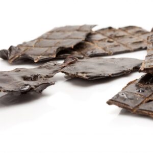 Close-up of dark brown dried seaweed chips arranged on a white surface. The chips have a glossy finish and are irregularly shaped, showcasing a textured appearance.