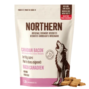 A bag of Northern Biscuits Canadian Bacon with Blueberries 1.36 kg for dogs, featuring a howling wolf illustration, with three square biscuits placed beside the bag.