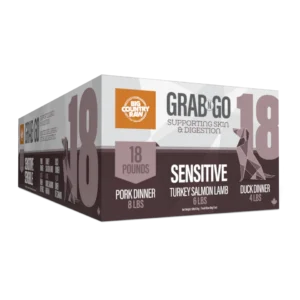 A box labeled "Big Country Raw Grab N Go 18," containing 18 pounds of pet food with flavors: pork dinner, turkey salmon lamb, and duck dinner. The box highlights "Sensitive" and "Supporting Skin & Digestion.