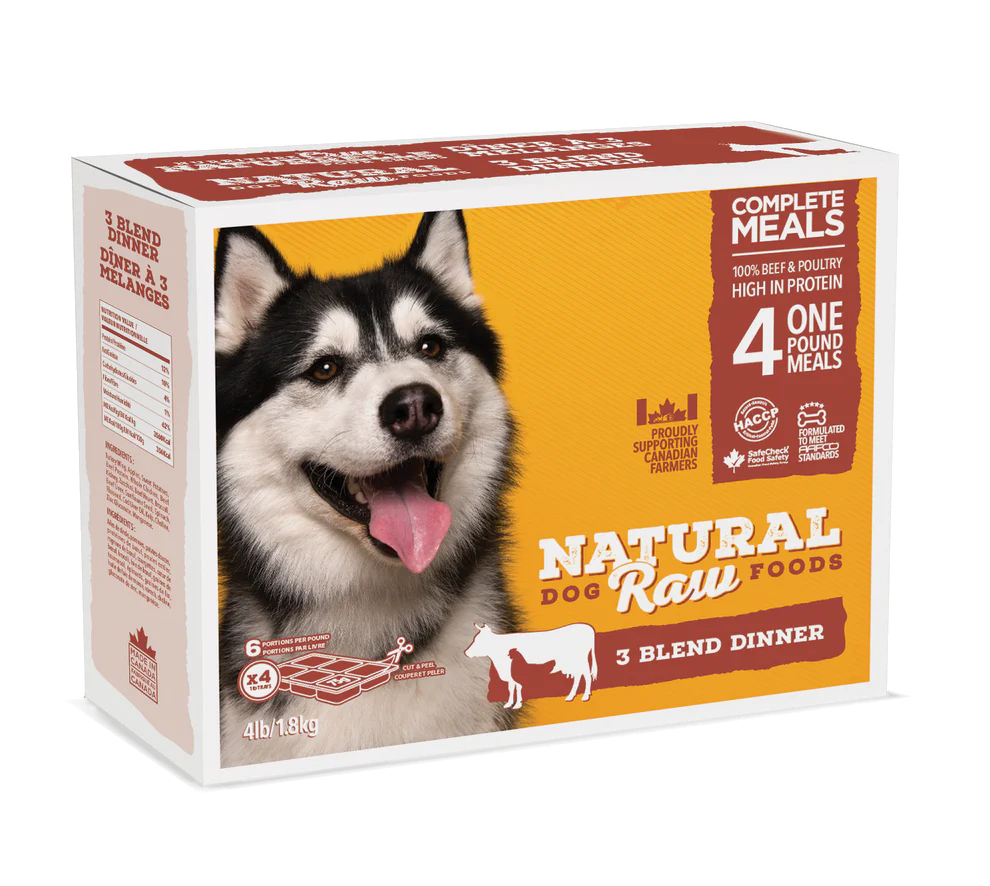 A rectangular package of Natural Raw Foods for dogs featuring a picture of a happy husky. The box advertises "Complete Meals," "4 One Pound Meals," "3 Blend Dinner," and "100% Beef & Poultry High in Protein." The weight is 4 lbs (1.8 kg).