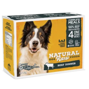 A bag of Natural Dog Raw Foods featuring a happy black and white dog on the front. The product is a beef dinner complete meal, containing 100% beef, high in protein. The packaging indicates it includes four 1-pound meals and has a weight of 4 lb (1.81 kg).