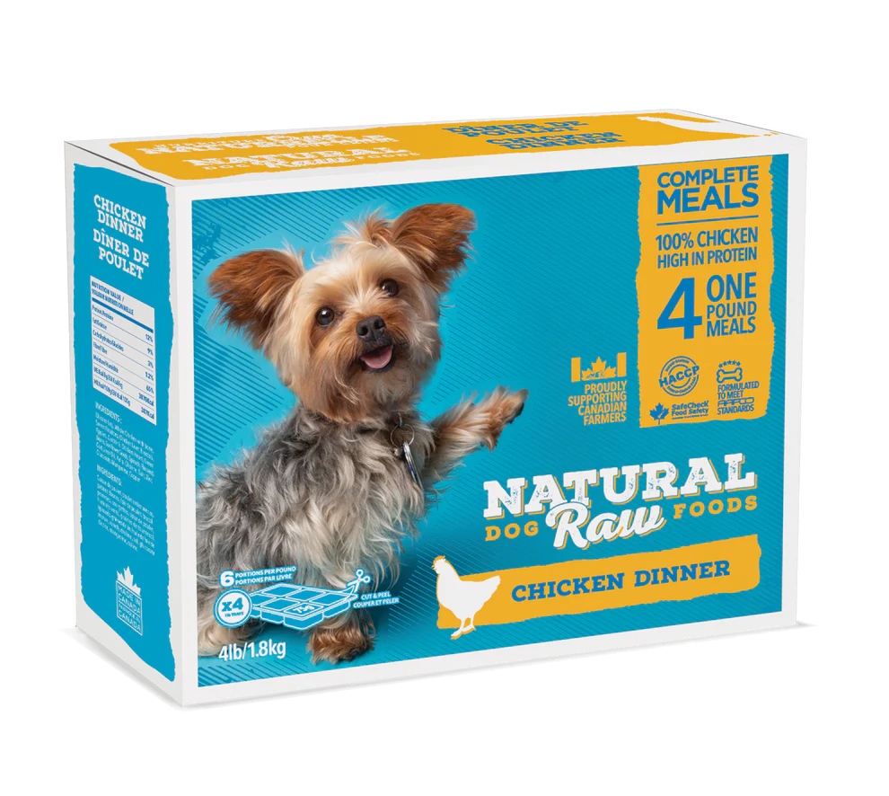 A box of "Natural Raw Foods" dog food featuring a small, happy dog. The product is labeled as "Chicken Dinner" and contains 100% chicken. The package includes four 1-pound meals and weighs 4 lbs (1.8 kg). The text highlights its high protein content.