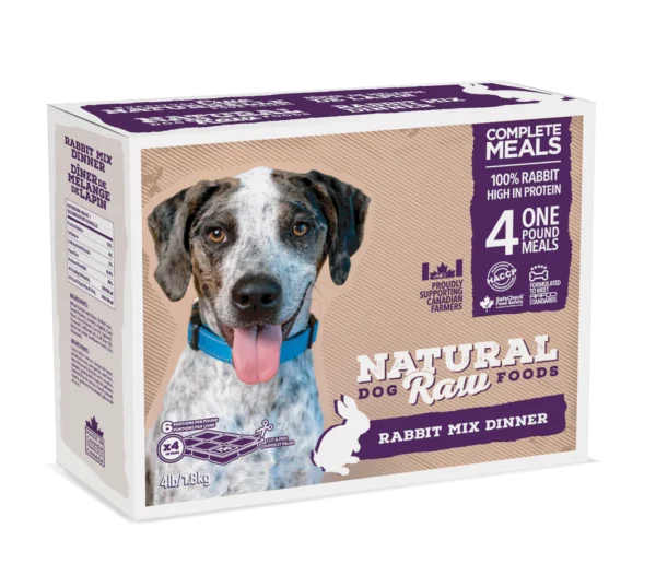 A box of Natural Raw Foods Rabbit Mix Dinner for dogs. The package features a smiling dog, various text highlighting its nutritional benefits, such as 100% rabbit high in protein, and includes meal preparation instructions. The box contains 4 one-pound meals.