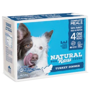 A box of Natural Raw Foods Turkey Dinner for dogs, featuring an image of a dog licking its lips. The box states it contains four 1-pound meals, made with 100% turkey and high in protein. The weight is 4 lbs (1.8 kg).