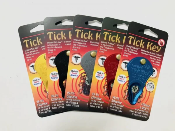 Five Tick Key tick removal tools in gold, orange, gray, red, and blue are displayed fanned out in their packaging on a white background. Each Tick Key package showcases the product’s effectiveness at safely removing ticks.