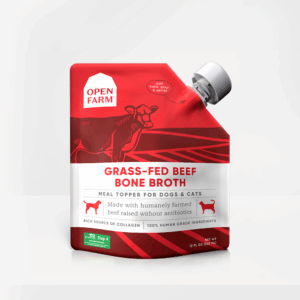 A red and white 355ml pouch of Open Farm Grass-Fed Beef Bone Broth for dogs and cats, showing a cow illustration and details about being humanely farmed, antibiotic-free, and a collagen source.