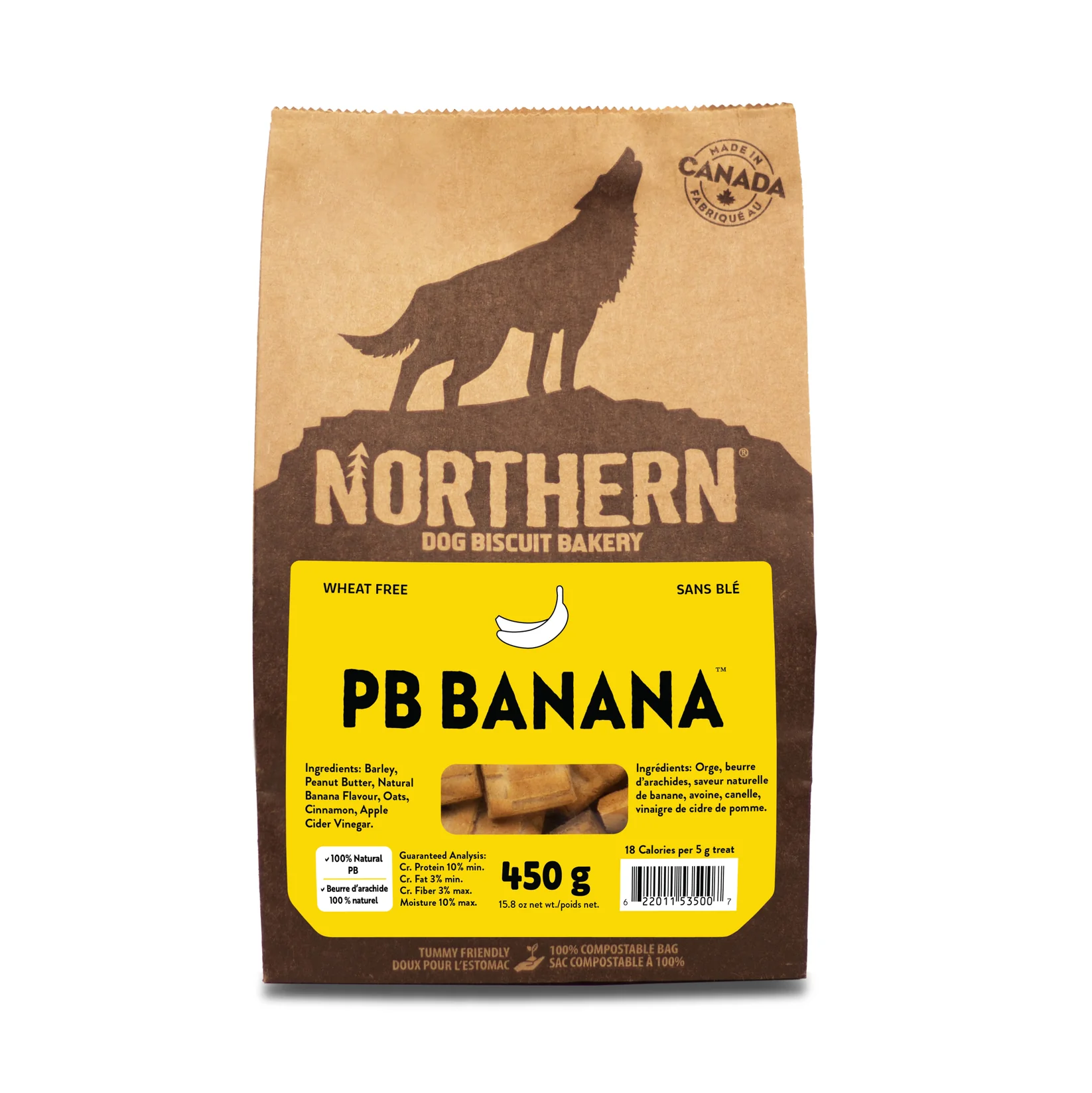 A brown paper bag of Northern Dog Biscuit Bakery PB Banana dog treats, featuring a wolf silhouette, the weight (450g), and a yellow label listing ingredients and stating it's wheat-free.