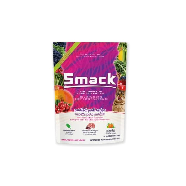 A colorful bag of Smack cat food labeled "Purrfect Pork Recipe." The package features images of fruits, vegetables, and a cat, and highlights that the food is raw, dehydrated, and made with natural ingredients.