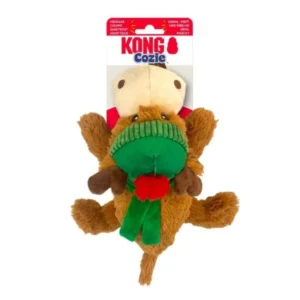 A plush dog toy resembling a brown reindeer with a green scarf and a red pom-pom, under the "KONG Cozie" brand packaging. The toy has antlers and a beige snout, with a red label at the top.