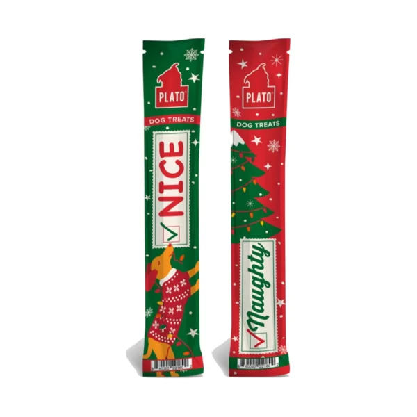 Two holiday-themed dog treat packages. One is green with "NICE" in red, featuring a reindeer. The other is red with "NAUGHTY" in green, decorated with snowflakes and stars. Both have a "PLATO" logo and a checkmark.