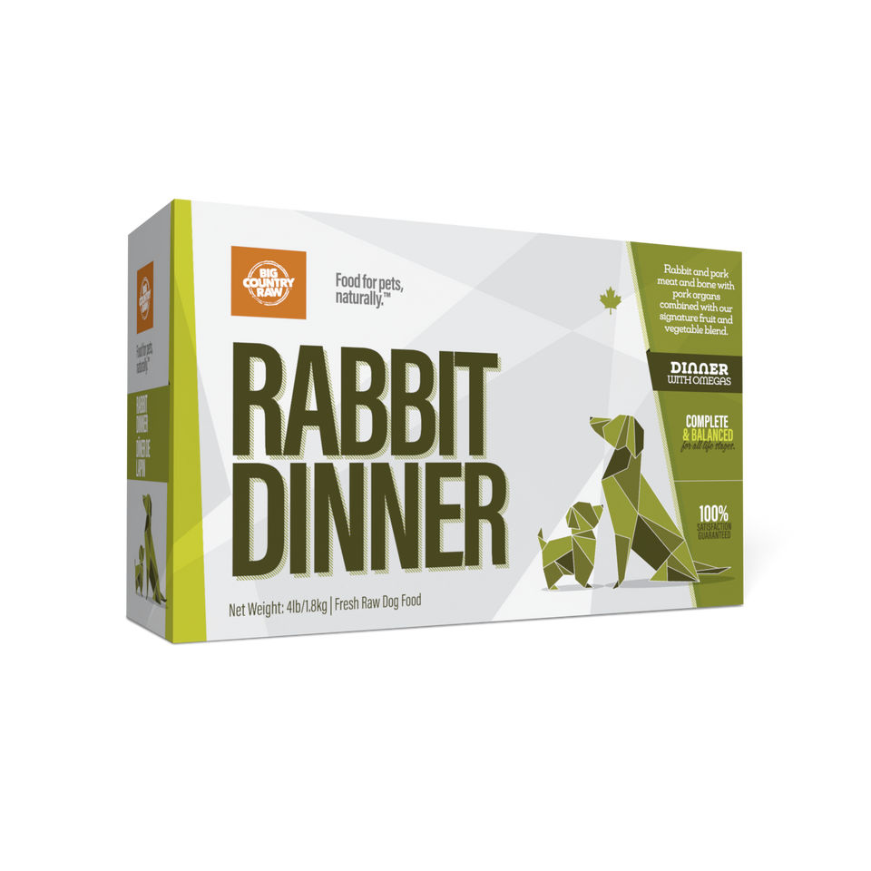 A box of "Rabbit Dinner" fresh raw dog food featuring green geometric animal designs and bold text. The packaging highlights natural ingredients and balanced nutrition.