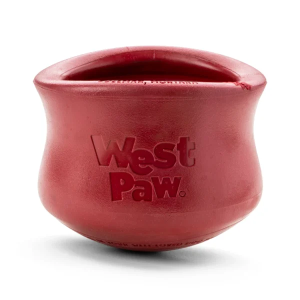 A red West Paw dog toy with a rounded, pot-like shape. The surface is smooth, and the brand name is embossed on the front.