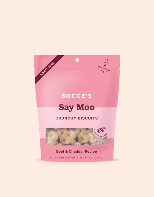 A pink and light pink resealable bag of Bocce’s Say Moo crunchy biscuits for dogs, labeled as wheat-free and made with beef and cheddar. The biscuits are visible through a clear window at the bottom.