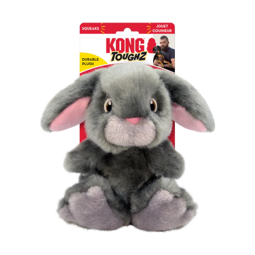 A gray plush bunny toy with pink inner ears and feet, featuring brown eyes and a white nose. The toy is part of the "Kong Toughz" collection, indicated by the packaging that highlights its durability and includes a squeaker.