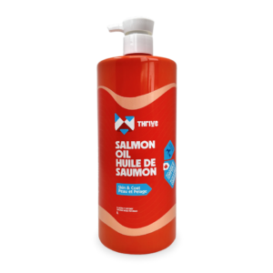 A large red bottle with a white pump, labeled "Thrive Salmon Oil 500 ml," promotes skin and coat health. The packaging includes English and French text.