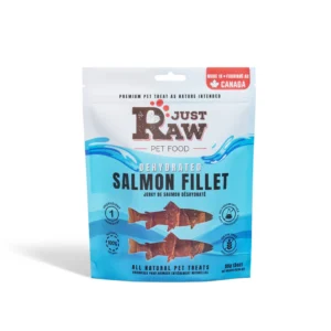 A blue and white resealable pouch labeled "Just Raw Pet Food" contains dehydrated salmon fillet treats for pets. The package displays salmon graphics, product details, and states it is made in Canada and all-natural.