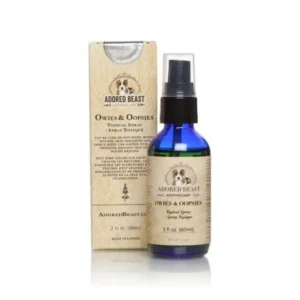 A blue spray bottle labeled “Adored Beast Skin Healthy Spray (Owies & Oopsies) 60ml” sits in front of its beige box packaging. Both feature a circular logo with an animal illustration and product information.