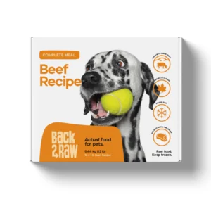 A box of Back2Raw Beef 12lbs (Complete) pet food shows a Dalmatian with a tennis ball, plus icons for premium ingredients, Canadian-made quality, and frozen storage instructions.