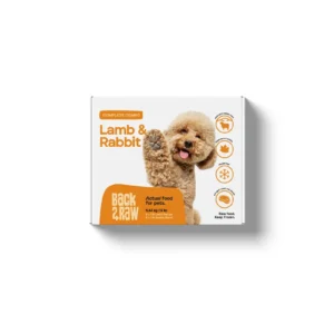 A white box with orange accents labeled "Back2Raw Complete Lamb & Rabbit 12 lbs" features a fluffy dog raising its paw and icons showing health benefits.
