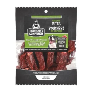 A package of The Butcher's Companion Sausage Bites for dogs, featuring a beef and veggie recipe. The front shows a picture of a happy dog, product details, and the label "real meat dog treats.