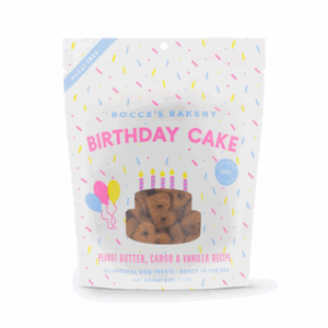 A white bag of BOCCE'S Birthday Cake 141 g dog treats features colorful confetti, balloons, and text noting peanut butter, carob, and vanilla flavors. The treats can be seen through a window on the front of the package.