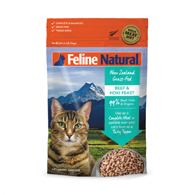 A bag of Feline Natural New Zealand Grass-Fed Beef & Hoki Feast cat food, featuring a photo of a tabby cat, mountains in the background, and an image of the food. The packaging highlights "99% Beef, Hoki & Organs.