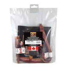 A clear plastic bag containing dog treats labeled "Puppy Love." The packaging features a black label and a red maple leaf indicating it is a Canadian product. Some treats are visible inside the bag.