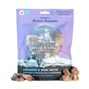 A package of Wild Vibes Treat Co. Kangaroo & Bone Broth pet treats for cats and dogs, with small chunks of the treat placed beside the bag. The packaging is purple and blue with illustrated animals.