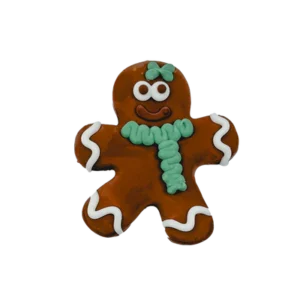 A gingerbread cookie shaped like a person, decorated with a green bow on its head and a matching green scarf. Its eyes and mouth are white, with white icing detailing on its arms and legs.