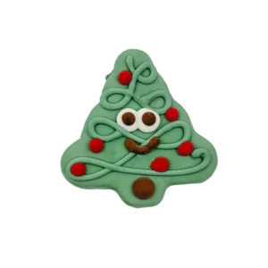 A cute Christmas tree-shaped cookie with white icing for eyes, brown icing for a smile, and red icing accents resembling ornaments. The cookie has green icing overall, creating a festive and playful design.