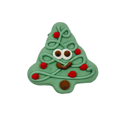 A cute Christmas tree-shaped cookie with white icing for eyes, brown icing for a smile, and red icing accents resembling ornaments. The cookie has green icing overall, creating a festive and playful design.