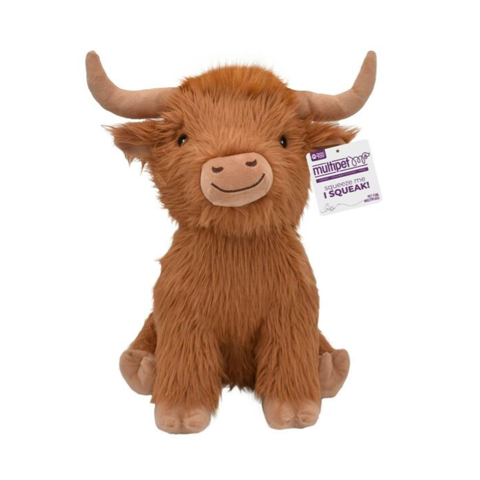A brown, plush Highland cow toy with long fur, two curved horns, a smiling face, and a tag attached to its ear that says "multipet nob SQUEAK." The toy is sitting upright against a white background.