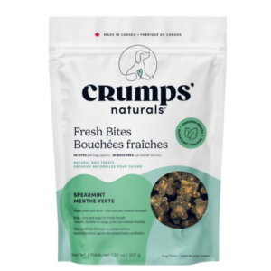 A white and green bag of Crumps’ Naturals Fresh Bites dog treats, spearmint flavor, showing product pieces through a clear window. The packaging highlights natural ingredients and is labeled as made in Canada.