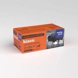 A bright orange box labeled "Healthy Paws Bison Complete 12x100g" contains 12 packs of small dog food. It features natural ingredients, is grain-free, and specially formulated for small dogs.