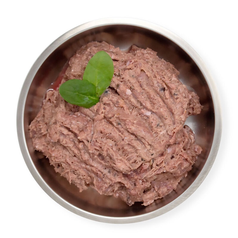 Big Country Raw Turkey Dinner 4x1lb in a metal bowl, filled with ground raw meat topped with two small green leaves.