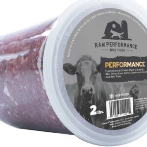 A two-pound container of Raw Performance Blend raw ground pet food featuring a cow and chicken on the label, which lists ingredients including chicken, beef liver, kidney, spleen, heart, and tripe.