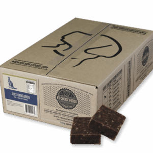 A cardboard box labeled "K9 Choice Kangaroo 20 lb" features black line art of a dog's head, nutrition facts, and a "Just Kangaroo" label. Two brown, square meat patties sit in front of the box.
