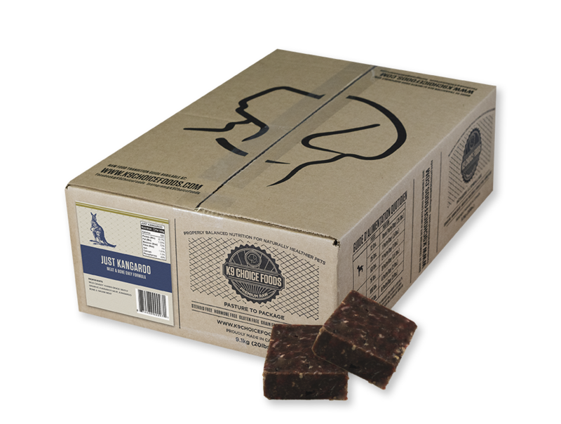 A cardboard box labeled "K9 Choice Kangaroo 20 lb" features black line art of a dog's head, nutrition facts, and a "Just Kangaroo" label. Two brown, square meat patties sit in front of the box.