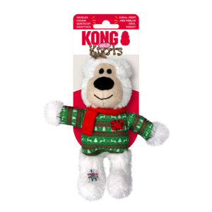 A plush toy shaped like a bear wearing a green sweater with red and white patterns, and a red scarf. It is part of the Kong Wild Knots collection, designed for pets, featuring a squeaker and knotted rope inside for durability.