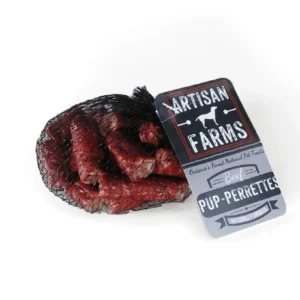 A mesh bag contains Artisan Netted Pup-Perettes Pre-Biotic Bites 390G, labeled "Artisan Farms: Ontario's Finest Natural Pet Treats. Naturally Smoked." These delicious red beef dog treats offer irresistible taste and pre-biotic health benefits for your pet.