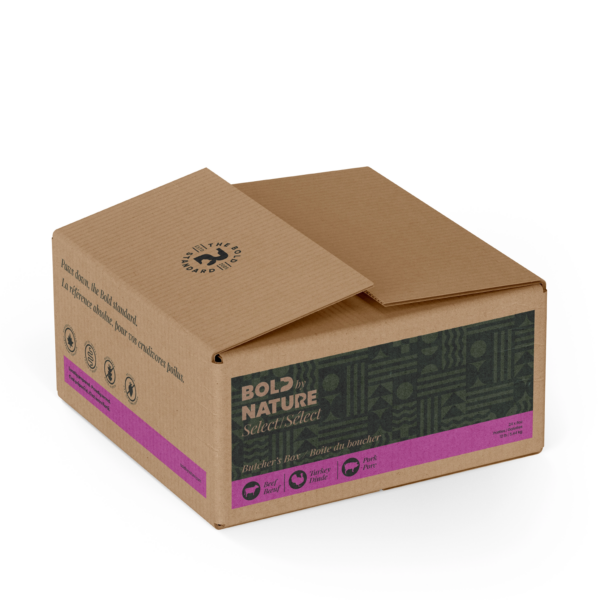 A cardboard box labeled "Bold by Nature Select/Select" with text and symbols indicating pet food for dogs. The box features green and pink accents and includes certifications such as 'All Natural' and 'Made in Canada'.