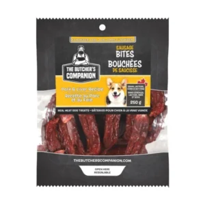 A package of The Butcher's Companion Sausage Bites for dogs, featuring pork and liver recipe. The package highlights grain-free ingredients and contains 250g of treats. A cartoon dog is pictured on the front.