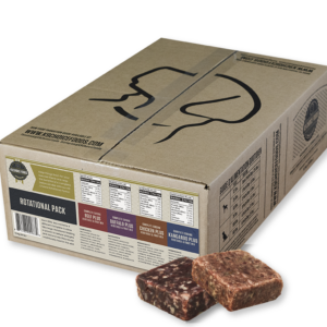 A cardboard box labeled "K9 Choice Rotational Pack 20 lbs" contains multiple packs of frozen raw pet food. The box displays different flavors: beef, chicken, buffalo, lamb, and kangaroo. Two raw pet food blocks are shown in front of the box.