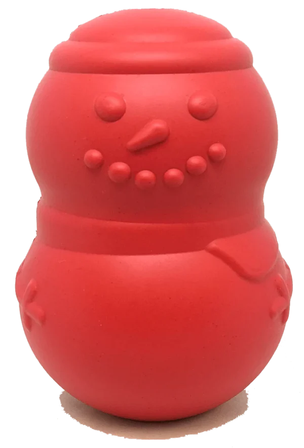 A red, rubber snowman-shaped toy with dotted eyes, a carrot-shaped nose, smile, and buttons. It's simple and smooth, resembling a festive winter figure with minimalistic features.