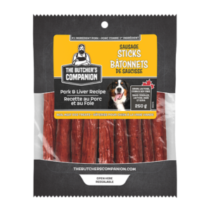 Packaging of The Butcher's Companion sausage sticks for dogs, featuring pork and liver recipe. The bag displays an image of a dog, ingredient highlights, and labels in both English and French. Contains 250 grams of product.